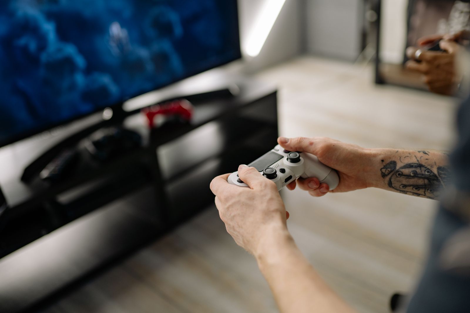 Player holding a game controller in front of a screen