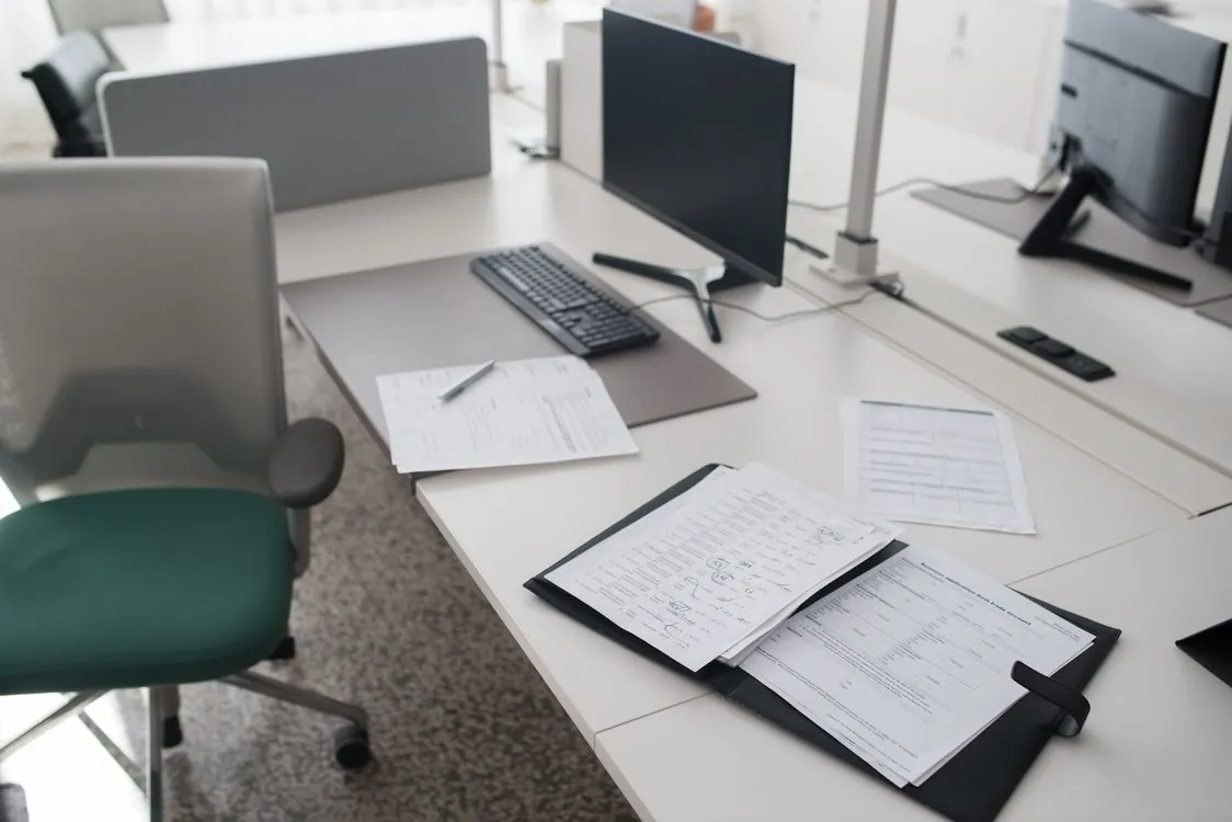 Stack of printed documents and a scanner on an office desk