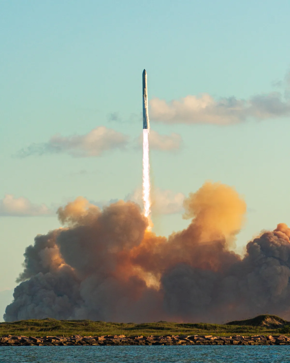 Starship and Super Heavy climbing above a cloud of exhaust after lifting off from Starbase, Texas, on Flight 11 in October 2025.